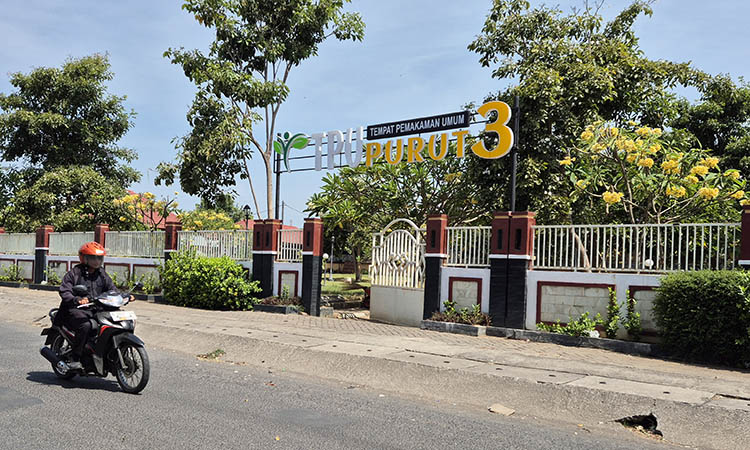 BUTUH TAMBAHAN: Pengendara motor saat melintas di depan TPU Purut 3 Kota Pasuruan. Pemkot membutuhkan tambahan TPU baru. Sayangnya, hal itu tertunda.