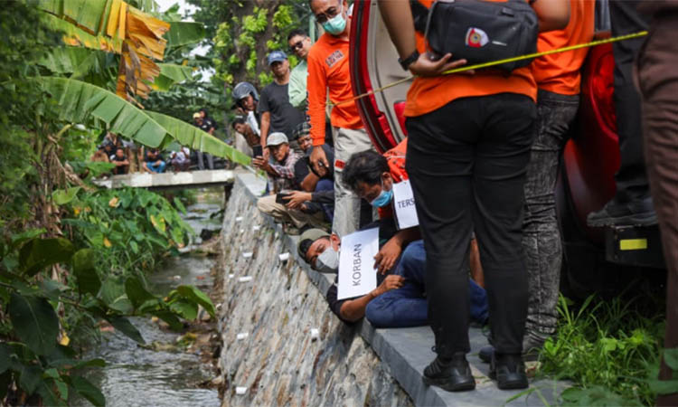 HARUS DETAIL: Petugas saat memperhatikan cara Suyitno membuang mayat Faradila di parir yang ada di Wonorejo.