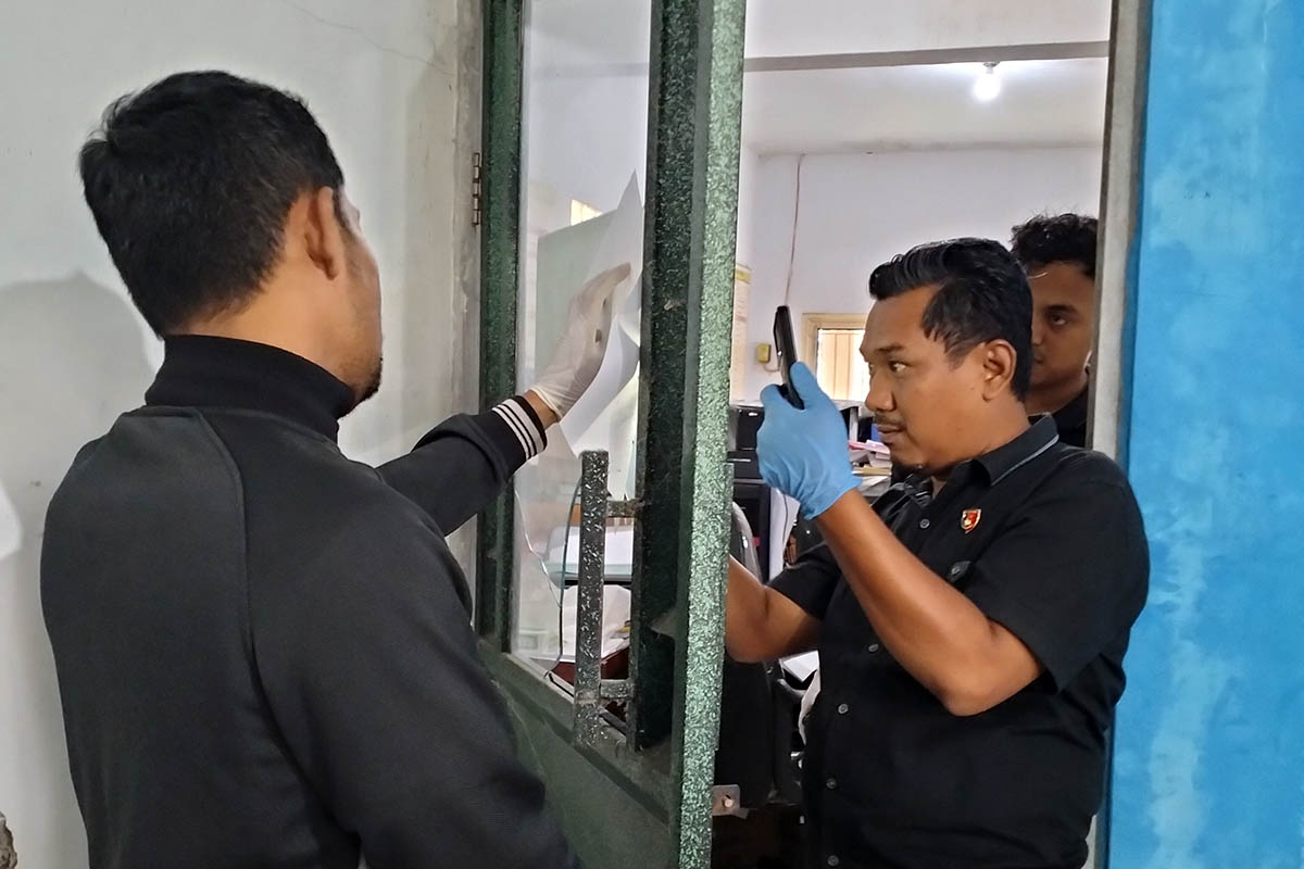 DICEK: Tim Inafis Satreskrim Polres Pasuruan saat melakukan pemeriksaan dan mengambil sidik jari di pintu kantor Desa Lebakrejo, Kecamatan Purwodadi.