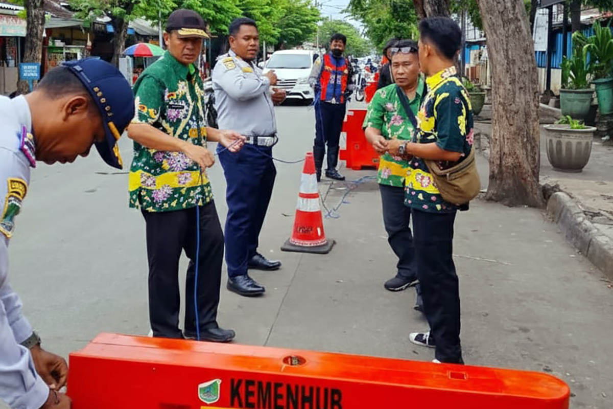 PEMBATAS: Petugas Dishub dan UPT Pasar saat memasang water barrier di depan Pasar Bangil. Hal ini dilakukan, untuk mencegah parkir liar.