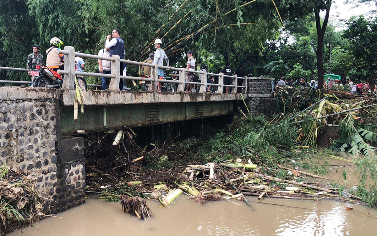 KERJA BAKTI: Warga sekitar bersama petugas terkait saat melakukan pembersihan material rumpun bambu di jembatan penghubung antara Desa Sumberbendo dan Ambulu, Kecamatan Sumberasih, Probolinggo