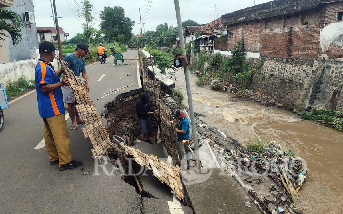 PENANGANAN DARURAT: Petugas memasang sesek untuk mencegah ambrolnya plengsengan sungai Kademangan lebih parah. (Mokhamad Zubaidillah/ Radar Bromo)