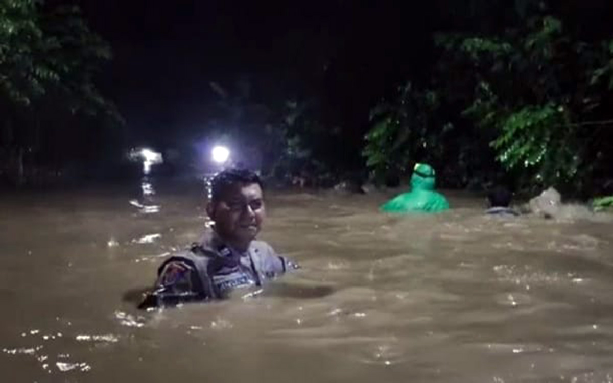 Salah satu warga Krejengan menerjang banjir setinggi dada orang dewasa, Sabtu malam (17/1). (Agus Faiz Musleh/ Radar Bromo)