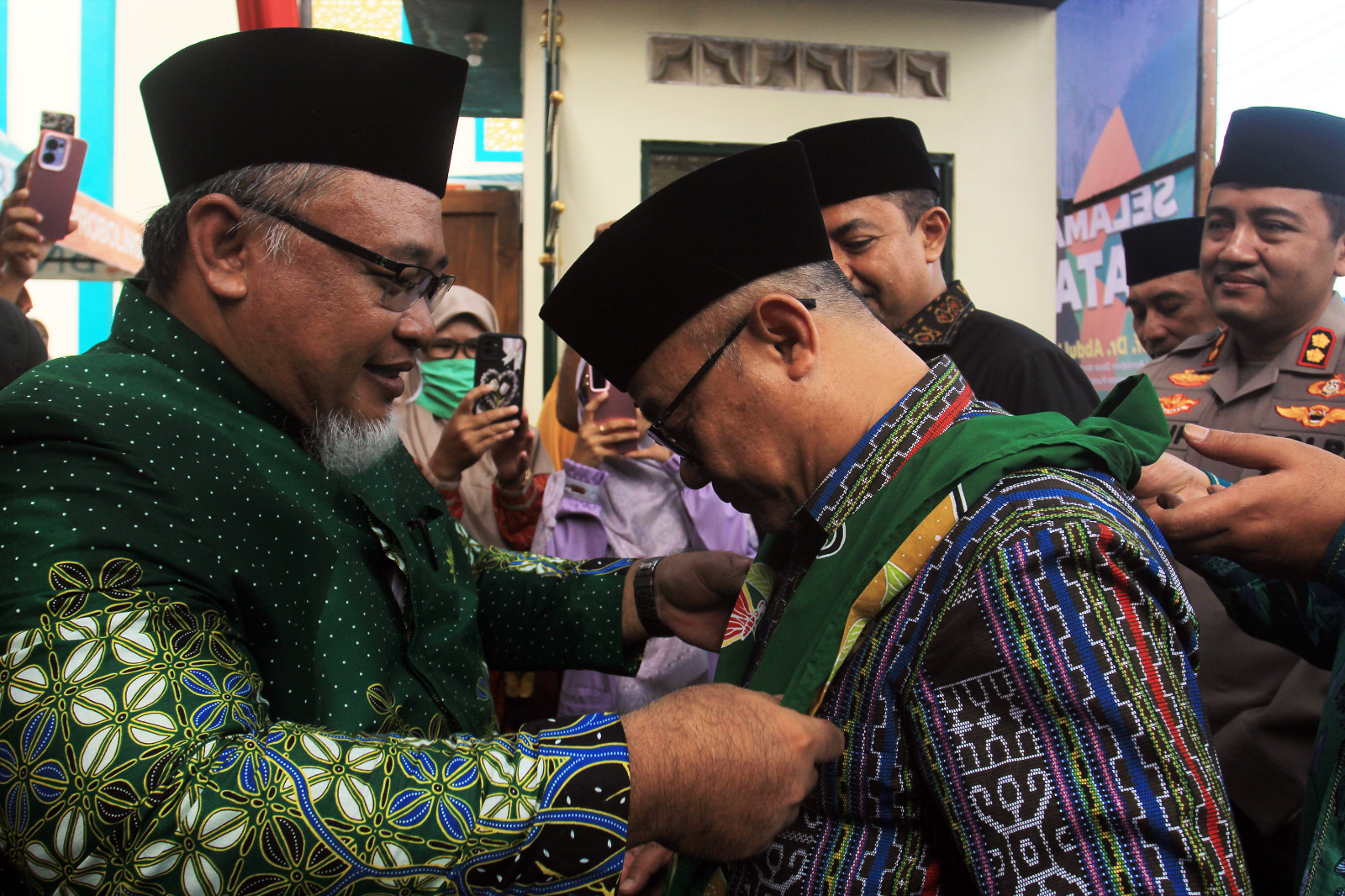 PENYAMBUTAN: Ketua PDM Kabupaten Probolinggo Sigit Prasetyo, S.T., M.Pd. mengalungkan selendang selamat datang kepada Menteri Dikdasmen RI Prof. Dr. Abdul Mu