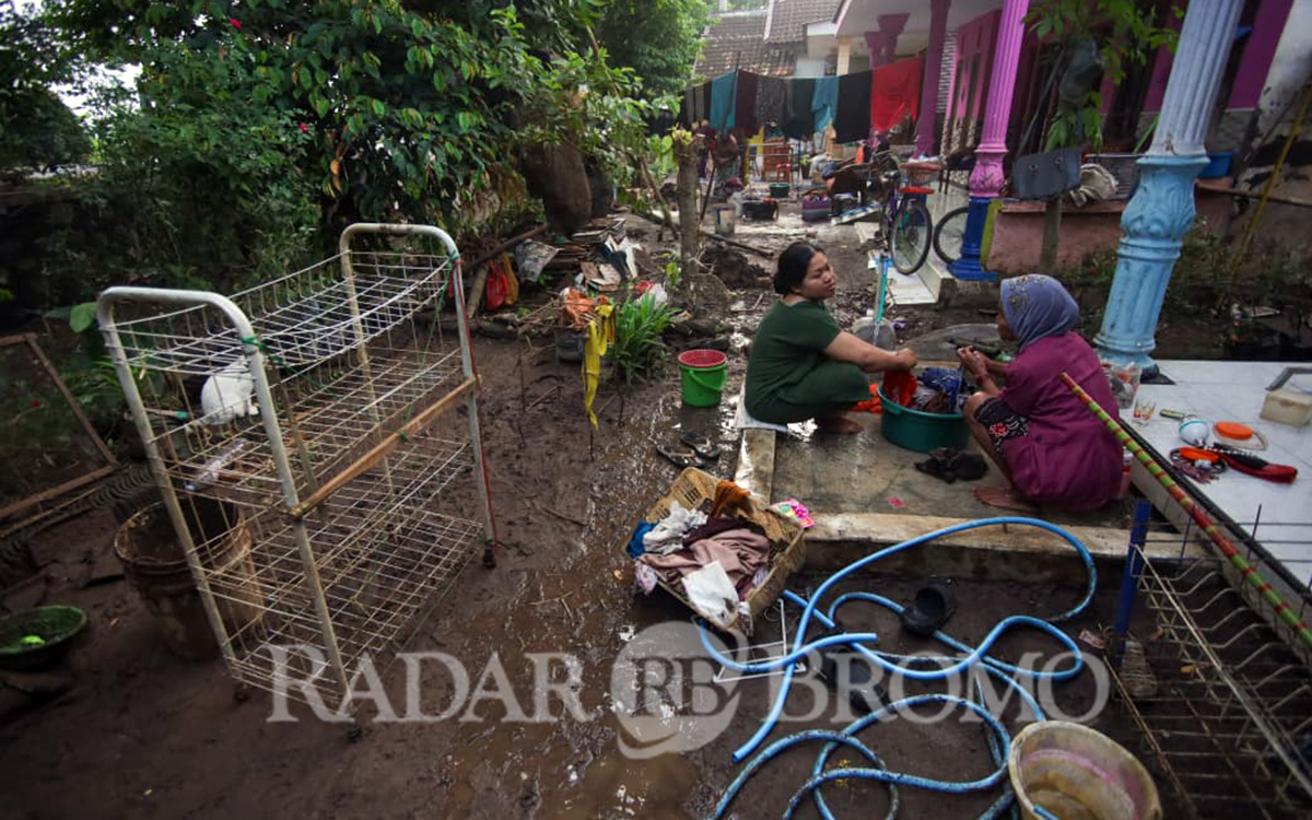 Warga Dusun Bibis, Kecamatan Sumberasih, Kabupaten Probolinggo yang masih sibuk bersih-bersih usai rumahnya terendam banjir.