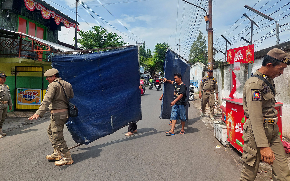 DITERTIBKAN: Sejumlah anggota Satpol PP Kota Probolinggo menertibkan lapak PKL di Jalan Supriadi, Selasa (20/1).