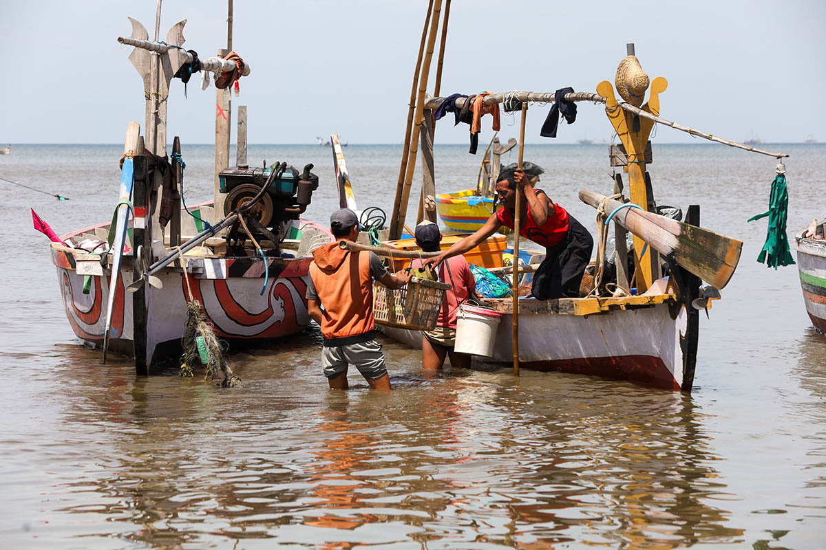 ANGKAT: Nelayan Kota Pasuruan sedang membawa tangkapan ikan dengan menggunakan kapal.