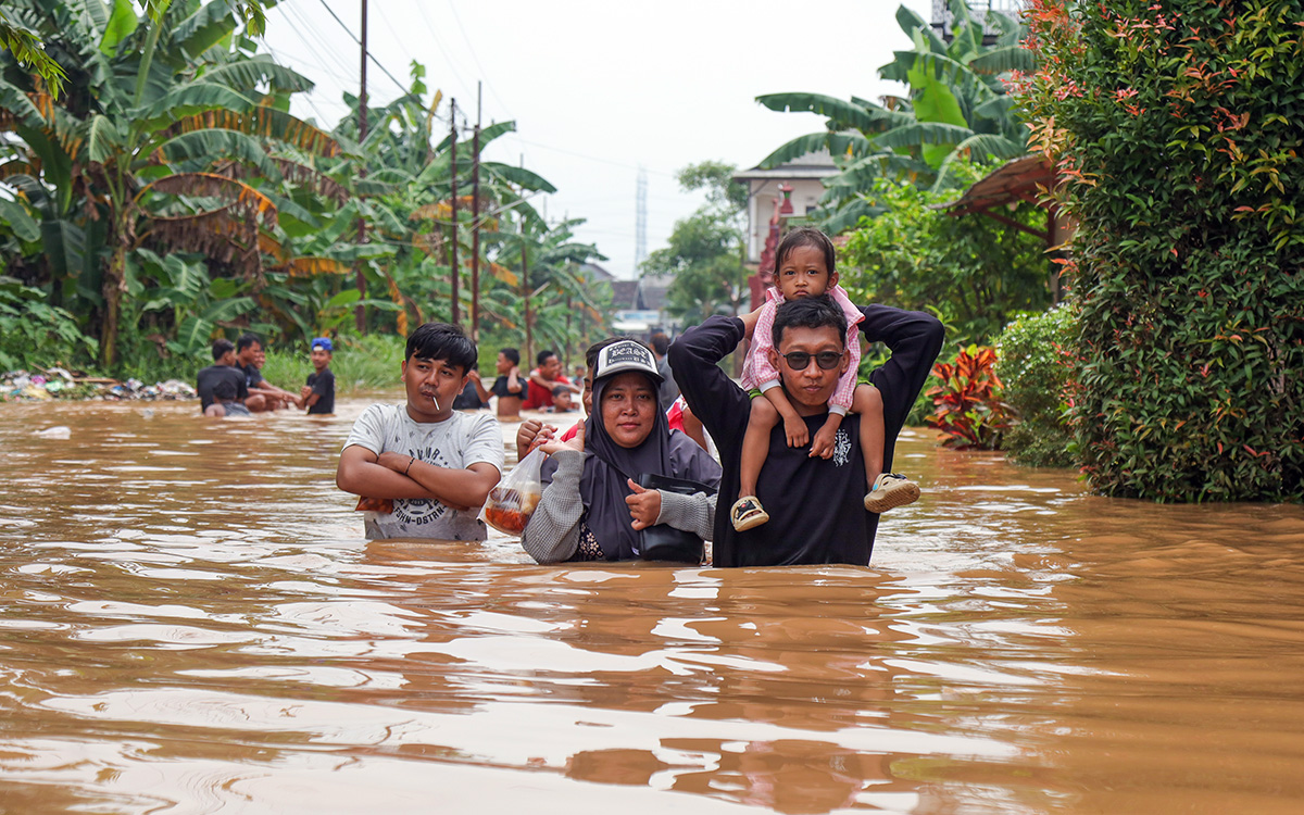 Warga menerjang banjir di Dusun Kebrukan, Kecamatan Grati, Kabupaten Pasuruan.