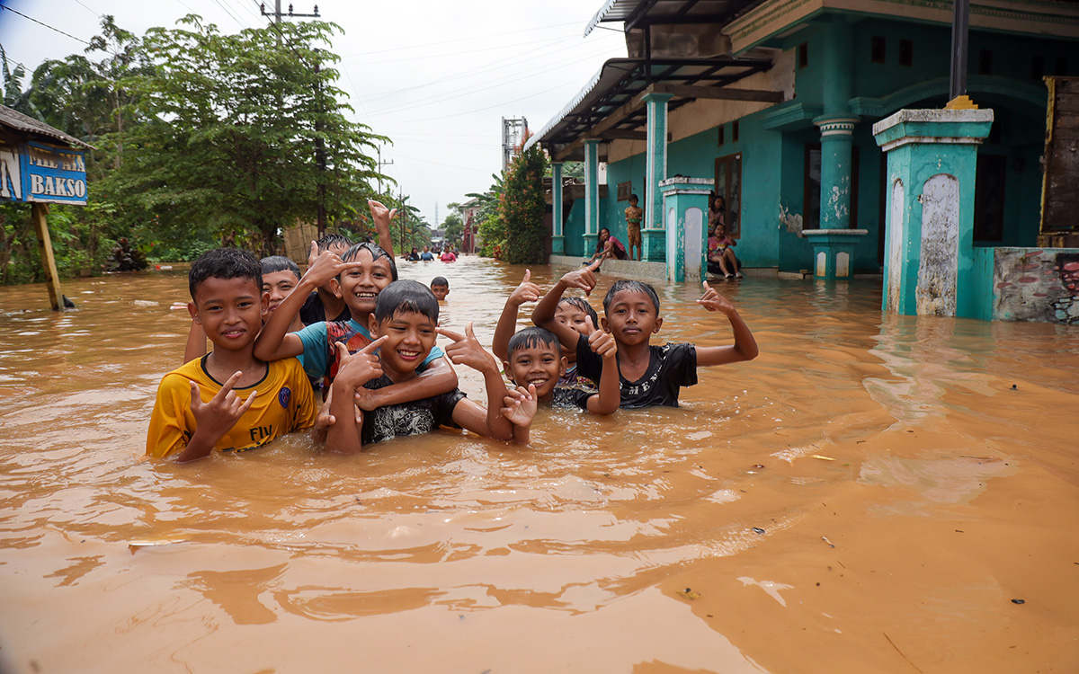 TETAP CERIA: Sejumlah bocah bermain di jalanan yang terendam banjir di Dusun Kebrukan, Grati,