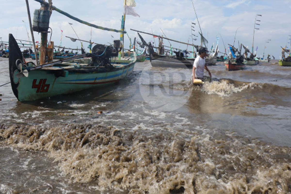 BERBAHAYA: Nelayan di pesisir Pasuruan dengan perahunya. Nampak ombak di perairan yang kencang.