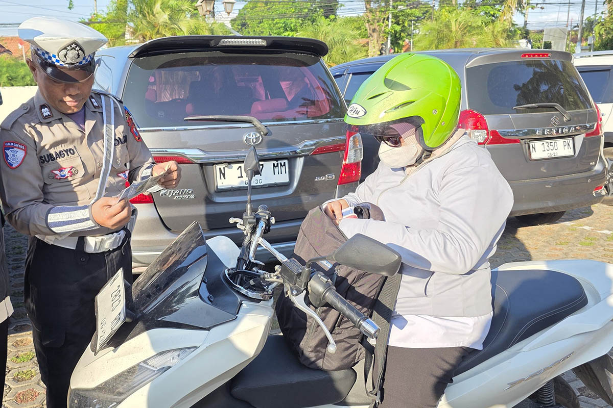 JANGAN NEGOSIASI: Petugas mengecek kelengkapan surat-surat kendaraan pengendara motor yang melintas di ruas jalan pantura Probolinggo beberapa waktu lalu.