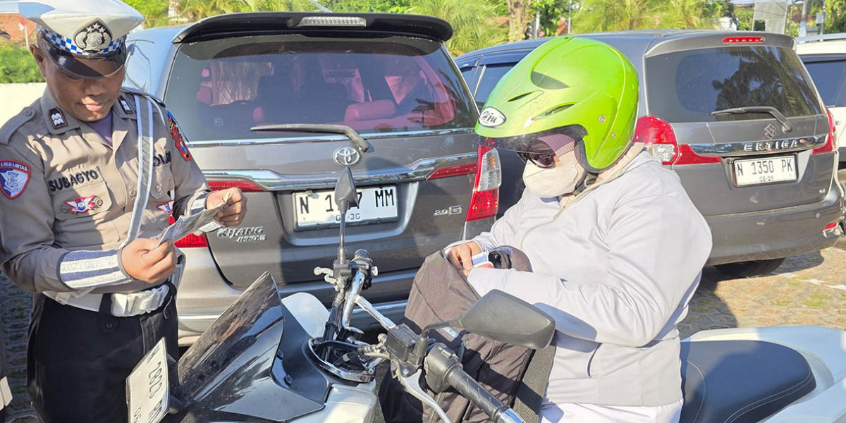 JANGAN NEGOSIASI: Petugas mengecek kelengkapan surat-surat kendaraan pengendara motor yang melintas di ruas jalan pantura Probolinggo beberapa waktu lalu.