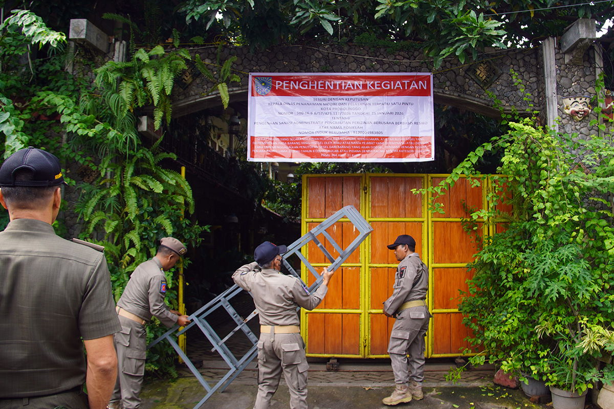 DITUTUP: Satpol PP Kota Probolinggo memasang banner penutupan Homestay Hadi&rsquo;s di Ketapang, Kecamatan Kademangan, Kota Probolinggo, Senin (26/1) pagi.
