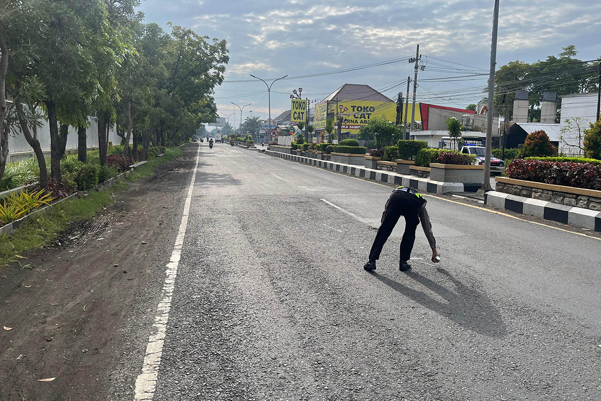 OLAH TKP: Petugas kepolisian saat melakukan olah TKP kecelakaan yang melibatkan seorang pelajar SMK di Pasuruan. Sejauh ini, perburuan terhadap sopir truk, masih dilakukan.