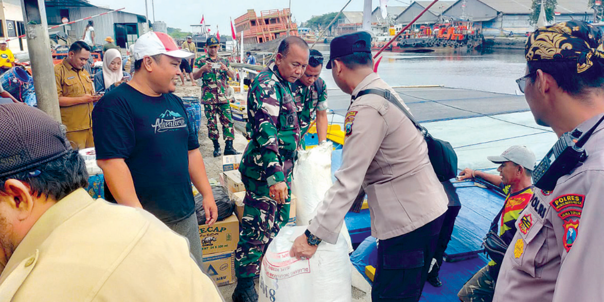 PENDISTRIBUSIAN: Anggota Polsek Sumberasih bersama Forkopimca menyalurkan bantuan karung pasir untuk Desa Gili Ketapang, Selasa (27/1).