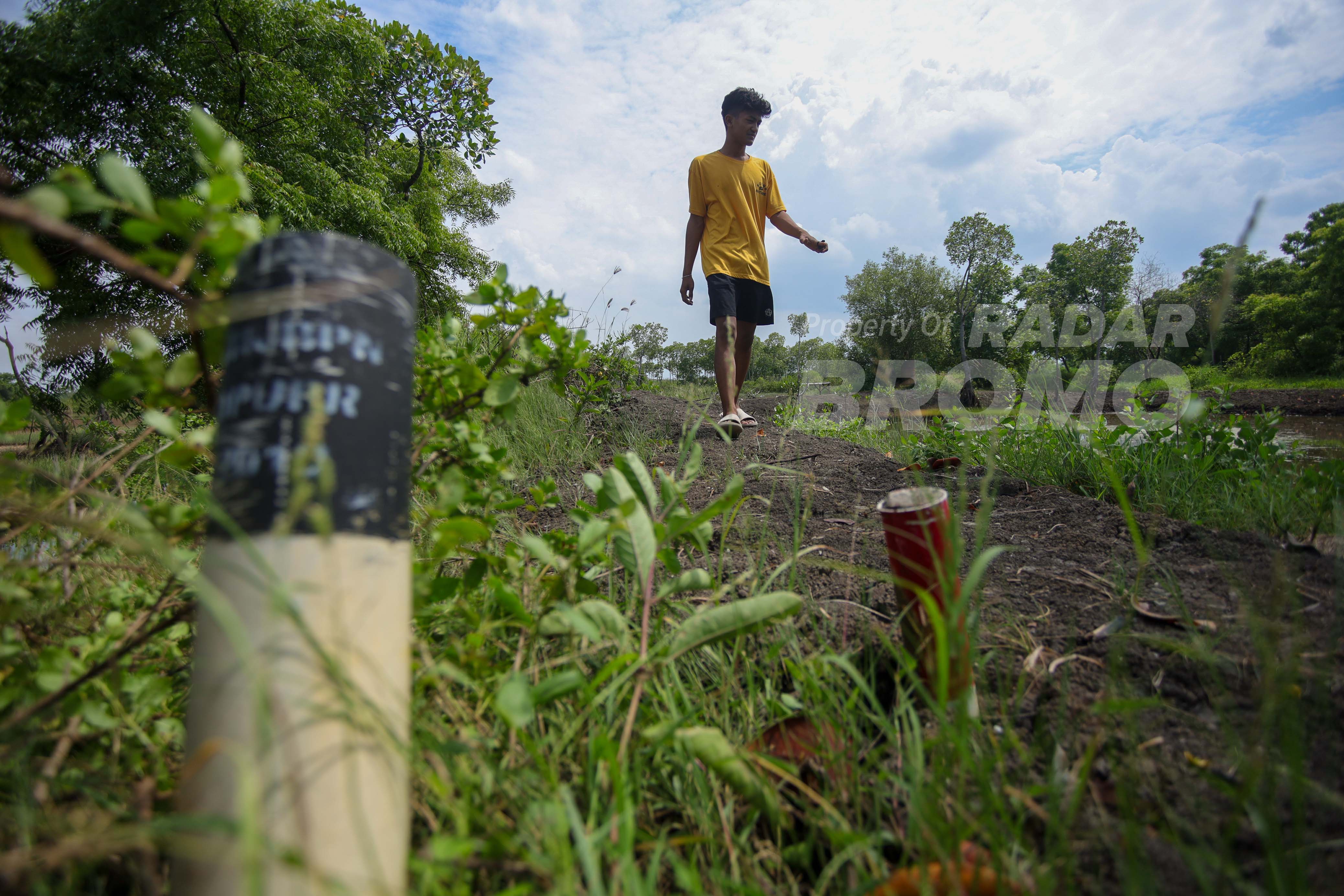 BAKAL JLU: Seorang warga melintas di lahan JLU di kawasan Tambak Jelakrejo, Kelurahan Blandongan, Kecamatan Bugul Kidul.