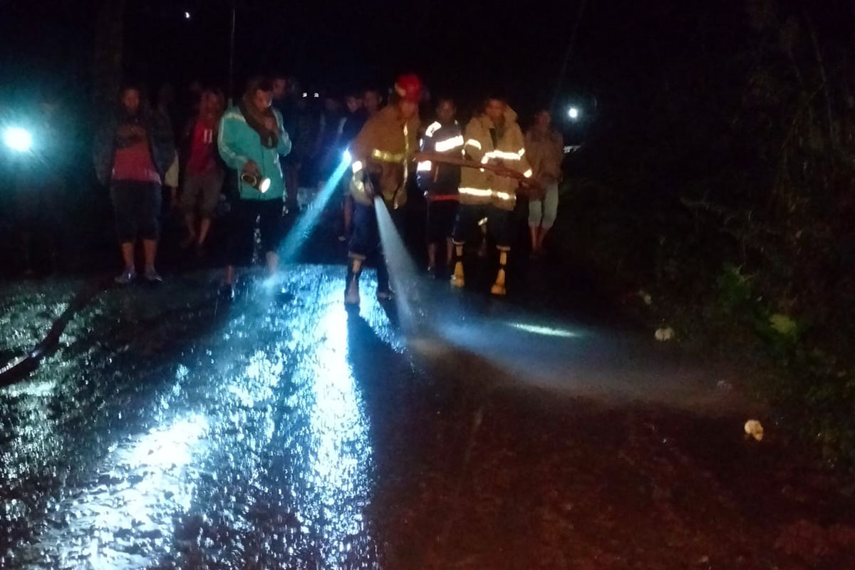 SEMPROT: Petugas Damkar Kabupaten Probolinggo menyemprot jalan kabupaten di Desa/Kecamatan Sumber, Rabu (28/1) malam.