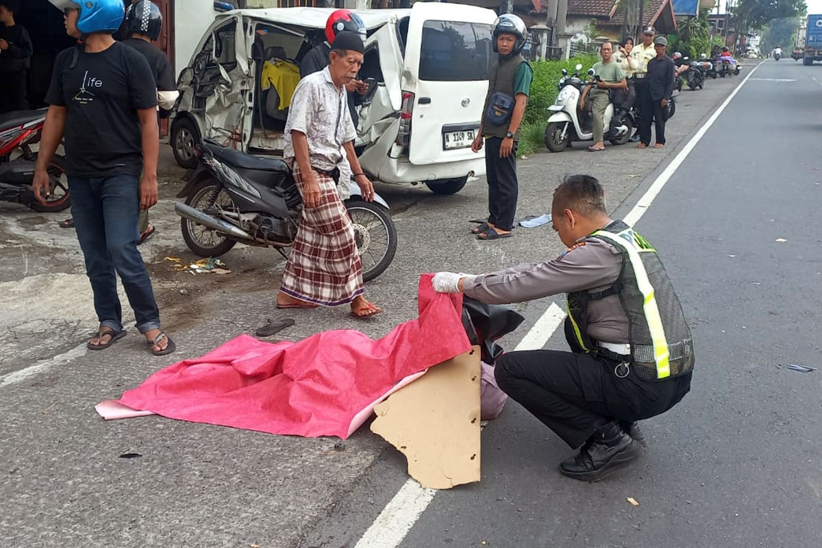 NAHAS: Petugas saat hendak mengevakuasi korban Yanti yang meninggal di lokasi kejadian usai Gran Max menabrak truk parkir muat keramik.