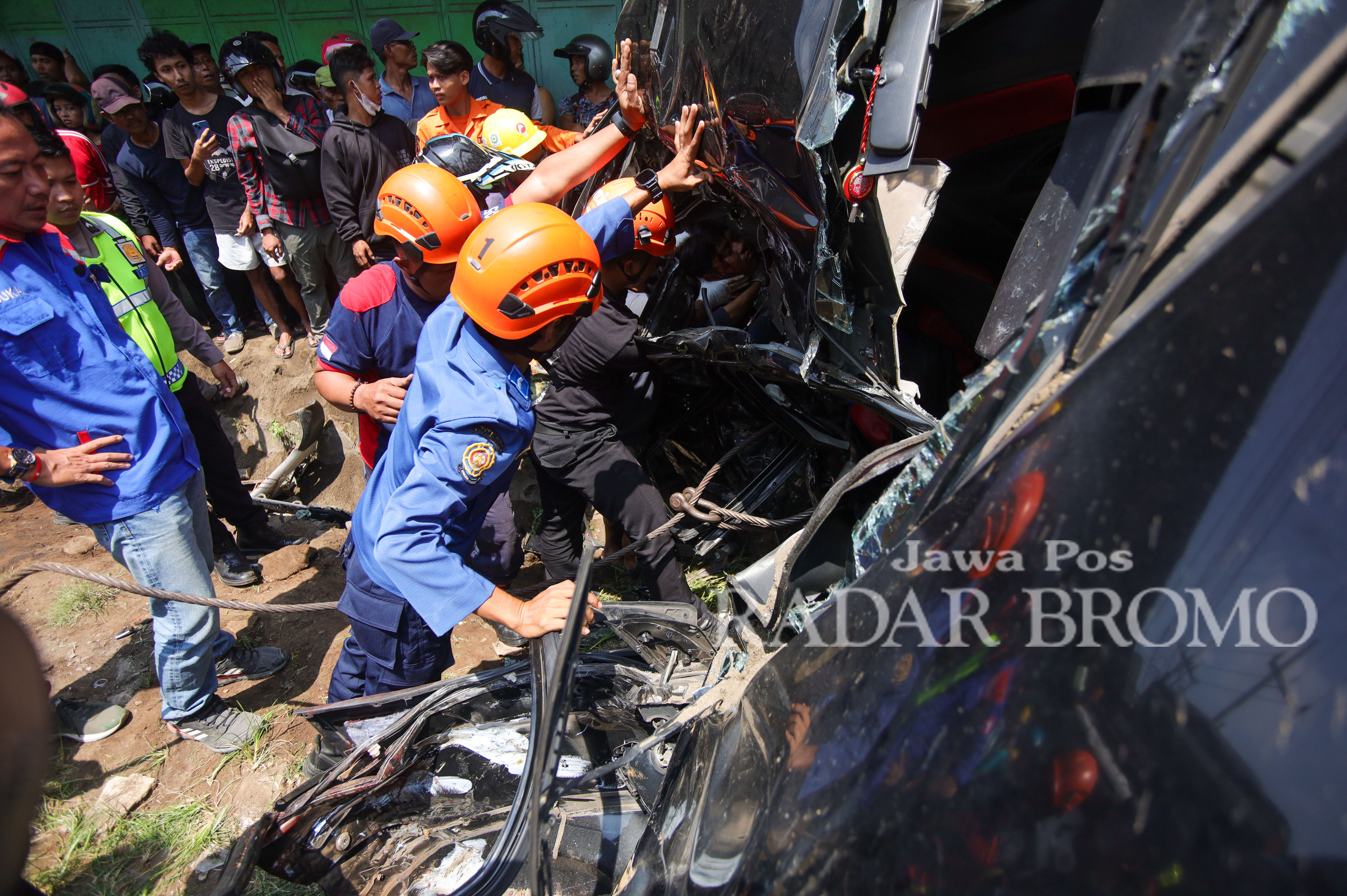Petugas Damkar saat mengevakuasi korban terjepit di body Avanza yang ringsek usai diseruduk dump truck di Pleret, Pasuruan (30/1).