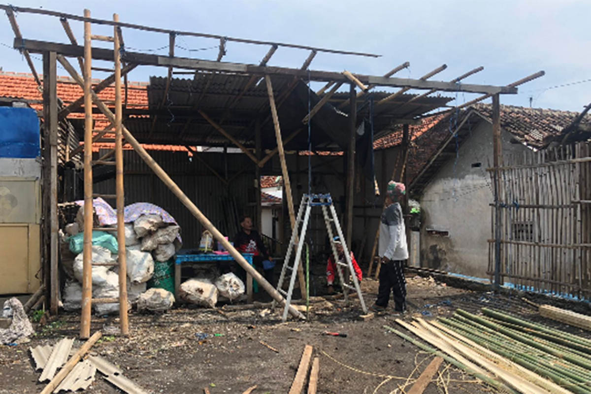 PERBAIKAN: Warga terdampak puting beliung, Muhammad Sudi, di Desa Tamansari, Kecamatan Dringu, Kabupaten Probolinggo saat memperbaiki garasinya, Sabtu (31/1).