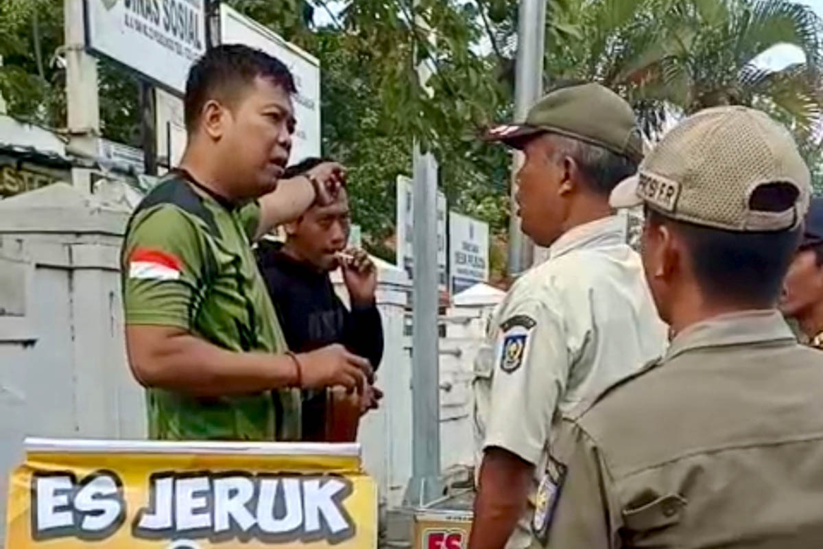 BERSITEGANG: Satpol-PP Kota Probolinggo bersitegang dengan personel Satpol-PP Kabupaten Probolinggo saat penertiban PKL di Jalan Ahmad Yani, Minggu (1/2) pagi.
