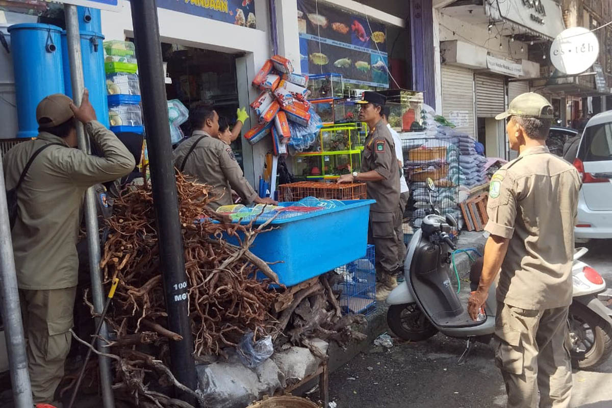 PERINGATAN: Personel Satpol PP Kabupaten Pasuruan saat memberikan warning agar para pedagang tidak berjualan di trotoar. Penindakan persuasif dilakukan, untuk memberikan pemahaman kepada pedagang.