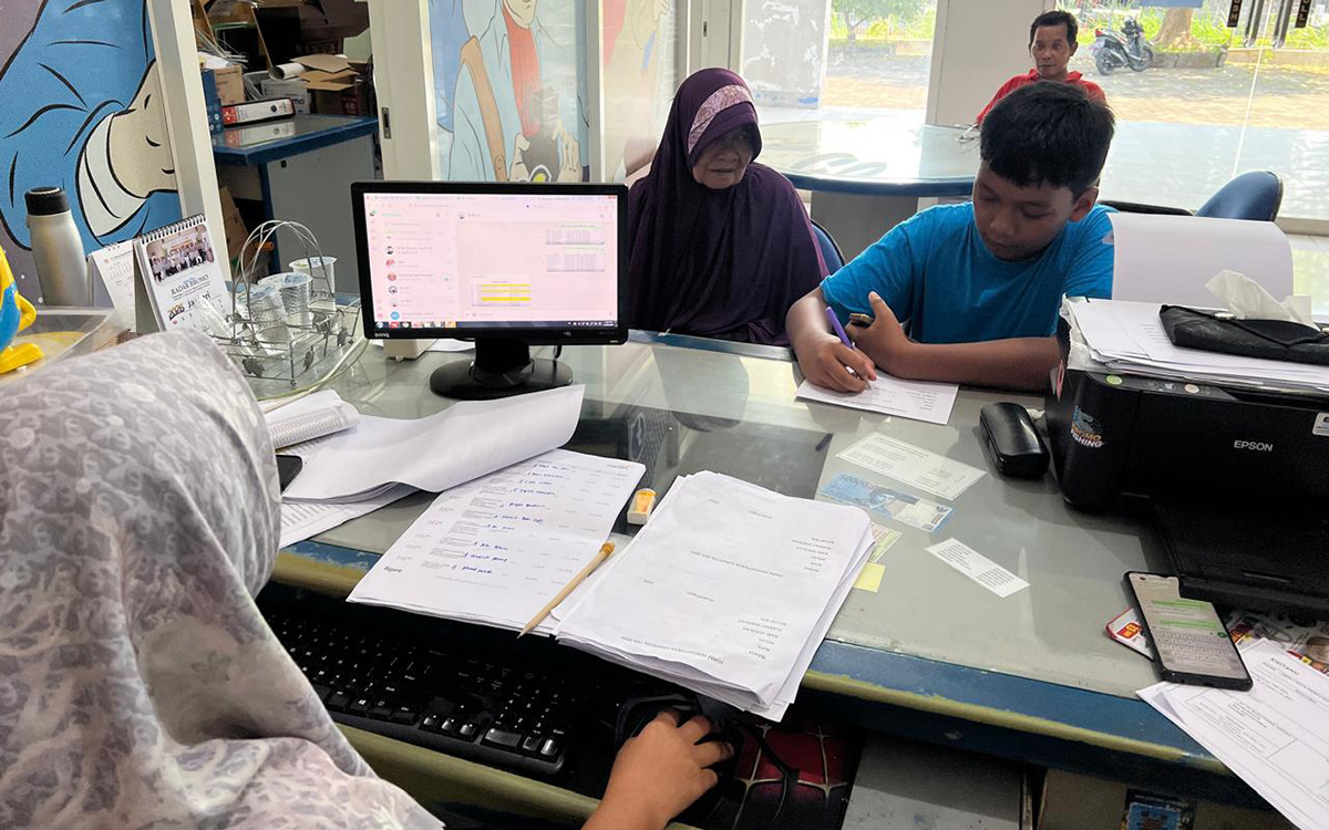 DAFTAR: Salah satu wali murid, Puji Ayem, menemani cucunya mendaftar TKA 2026 di kantor Jawa Pos Radar Bromo.