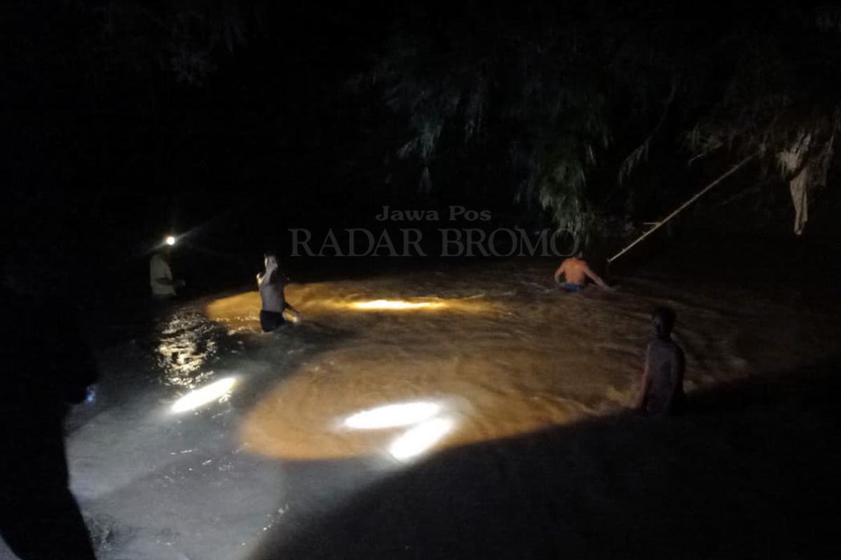 SISIR SUNGAI: Warga dan petugas menyisir sungai lokasi korban balita diduga hanyut di Tongas, Probolinggo, Selasa malam (3/2).
