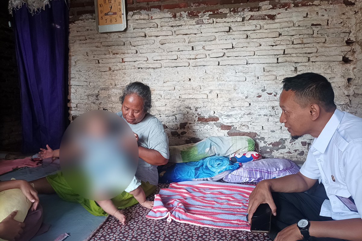 SUM menimang cucunya yang berhasil dipulangkan usai telantar di Johor, Malaysia. (Agus Faiz Musleh/ Radar Bromo)