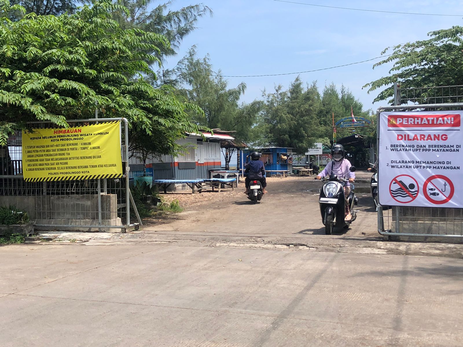 DILARANG: Sejumlah pengunjung melintasi pintu gerbang area wisata Kum-Kum di Pelabuhan Perikanan Pantai (PPP), Kecamatan Mayangan, Kota Probolinggo.