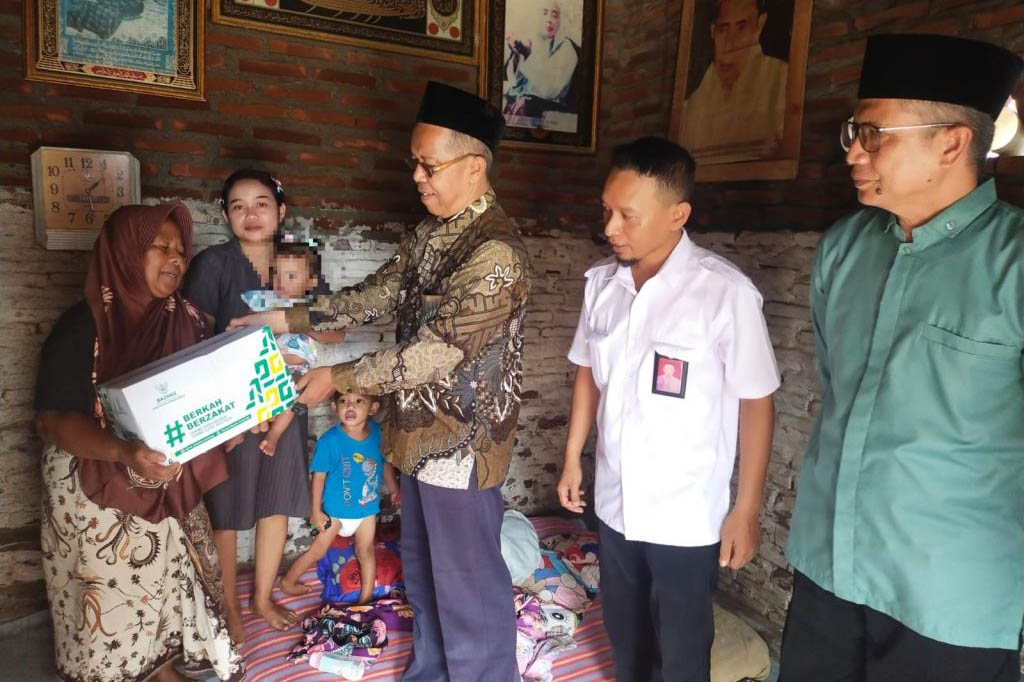 BANTU: Ketua Baznas Kabupaten Probolinggo H. Ahmad Muzammil menyerahkan bantuan paket sembako kepada nenek dari bayi SA.