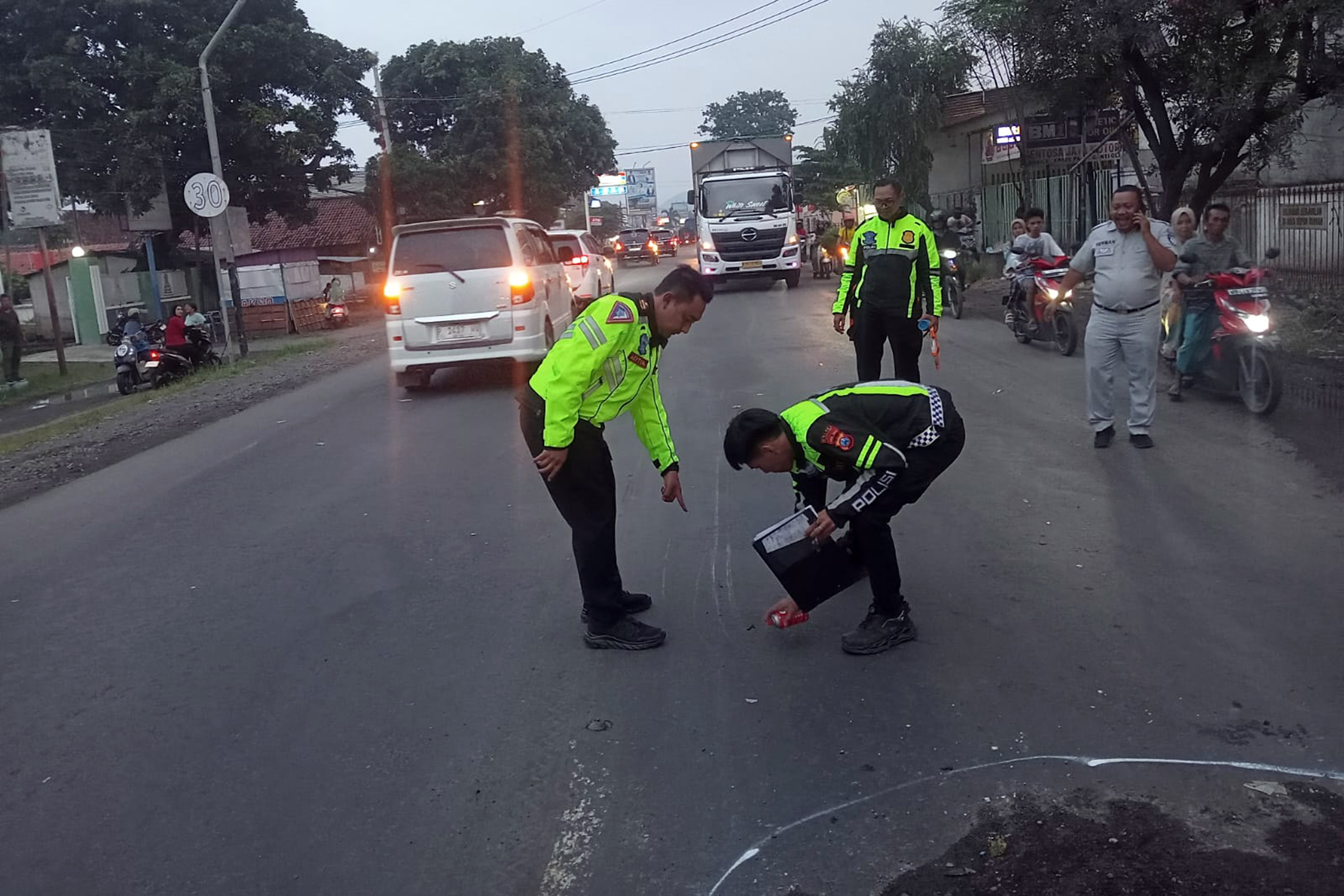 JALUR PANTURA: Petugas Satlantas saat melakukan olah TKP kecelakaan maut yang merenggut nyawa 3 remaja di jalur pantura Sukodadi, Paiton, Probolinggo, Selasa sore (10/2). (Istimewa)