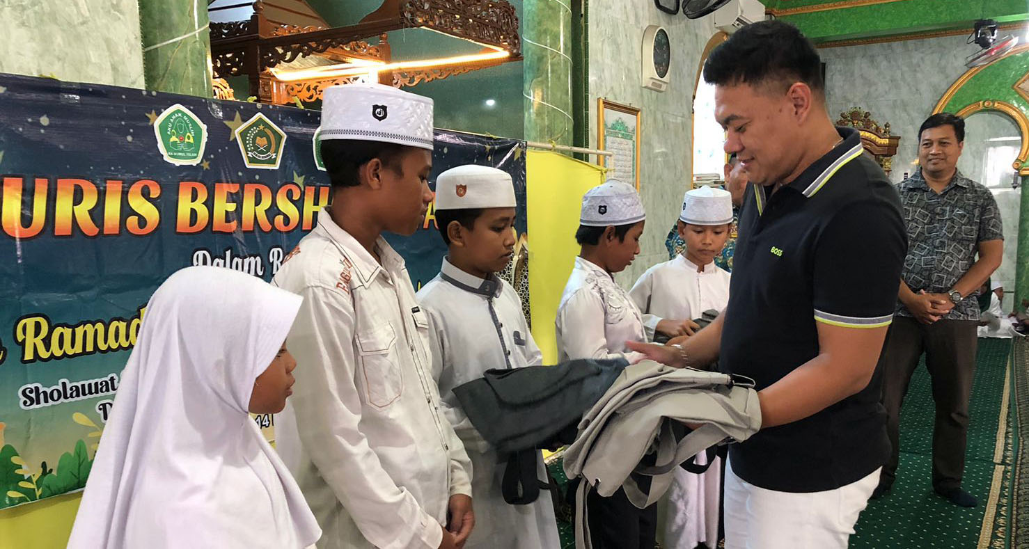 PEDULI: Owner PT Anugerah Jaya Megah (AJM), Fajrin Sidik Kurniawan saat memberikan tas pada sejumlah murid MI Nurul Islam.