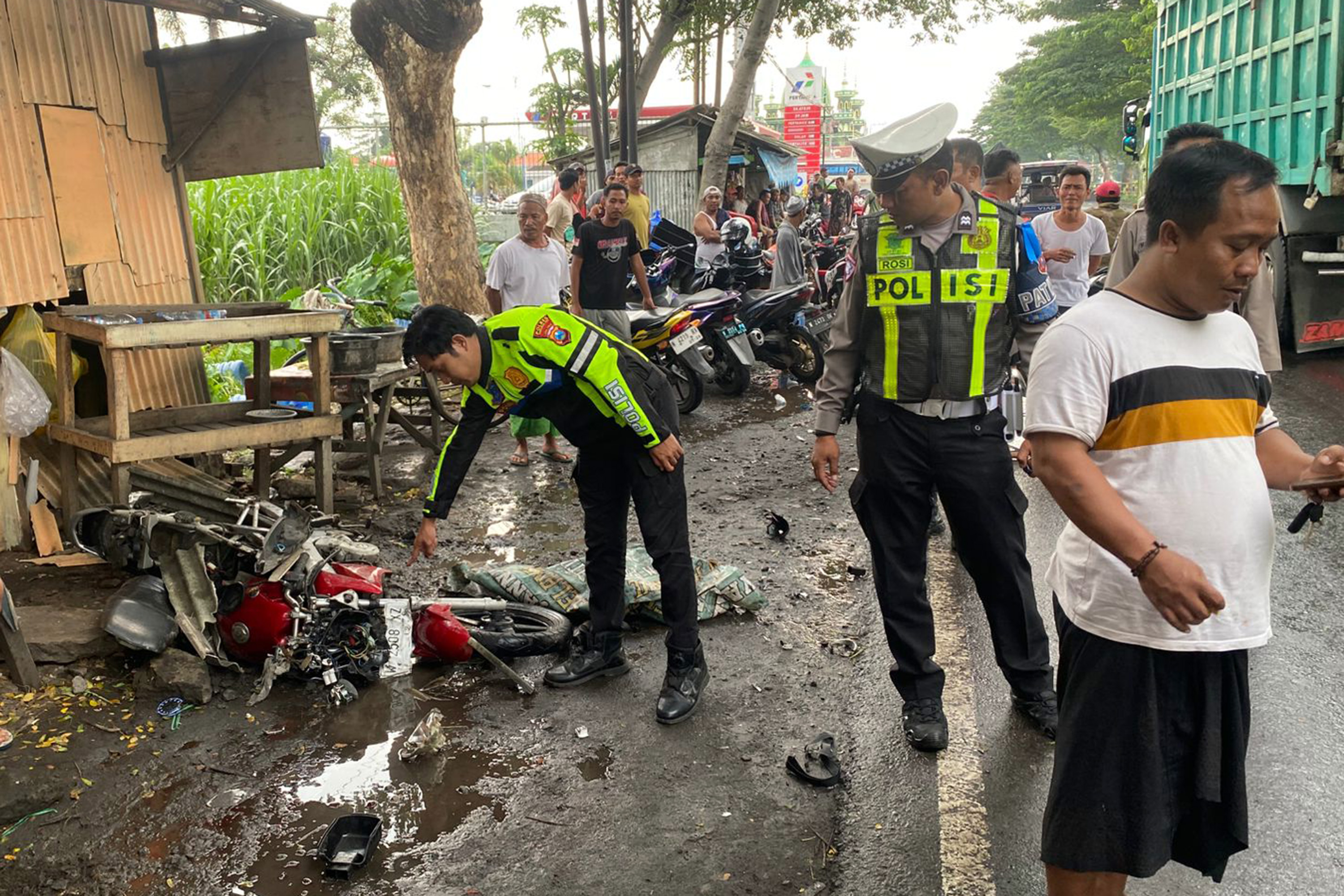 EVAKUASI: Anggota Satlantas Polres Probolinggo Kota mengevakuasi kendaraan di Desa Banjarsari, Sumberasih, Kabupaten Probolinggo, Kamis (12/2) siang.