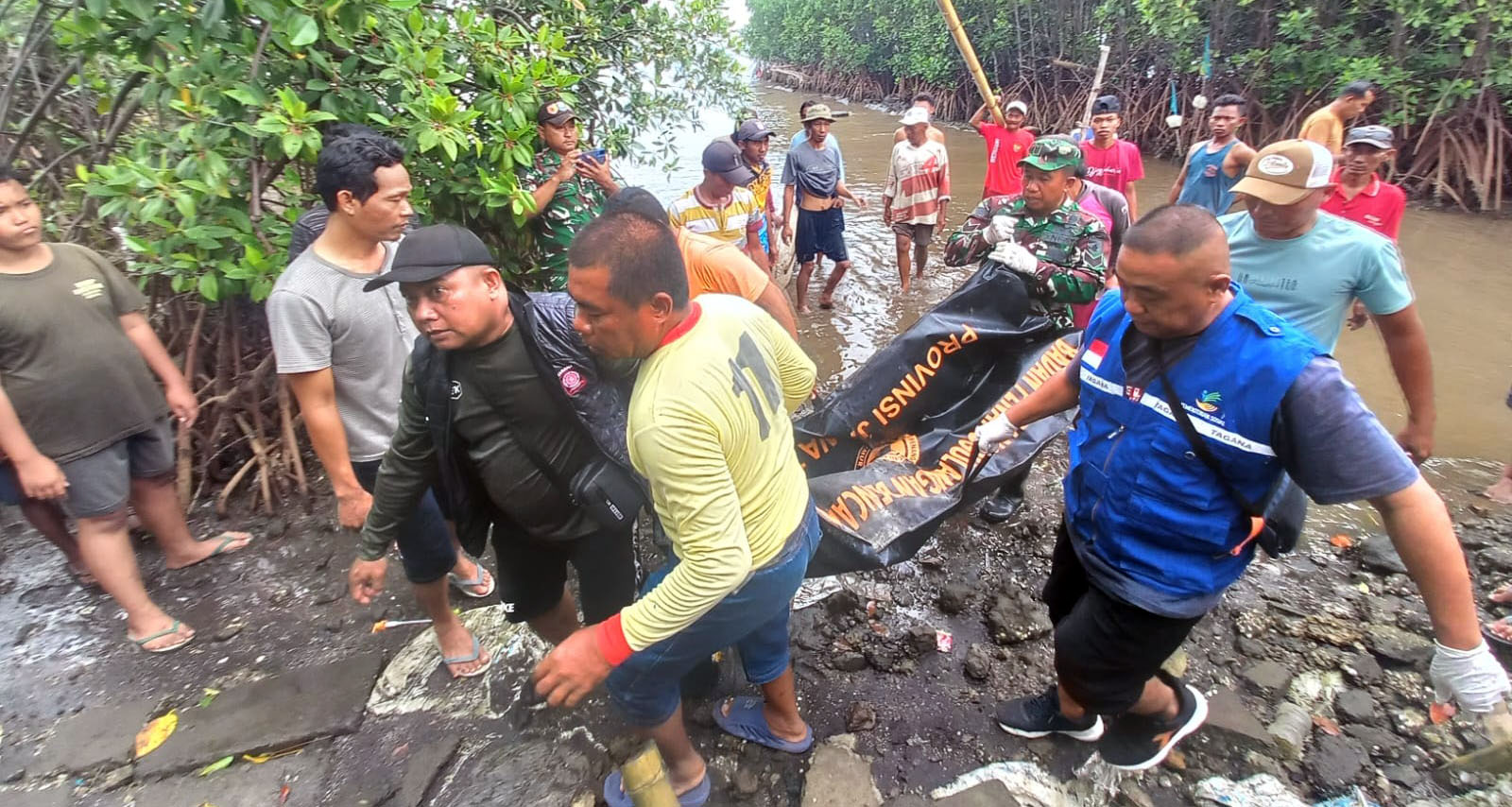 EVAKUASI: Sejumlah relawan kesehatan dan warga saat mengevakuasi korban Djema`i, 73 yang meninggal di Pantai Tugu, Kecamatan Dringu