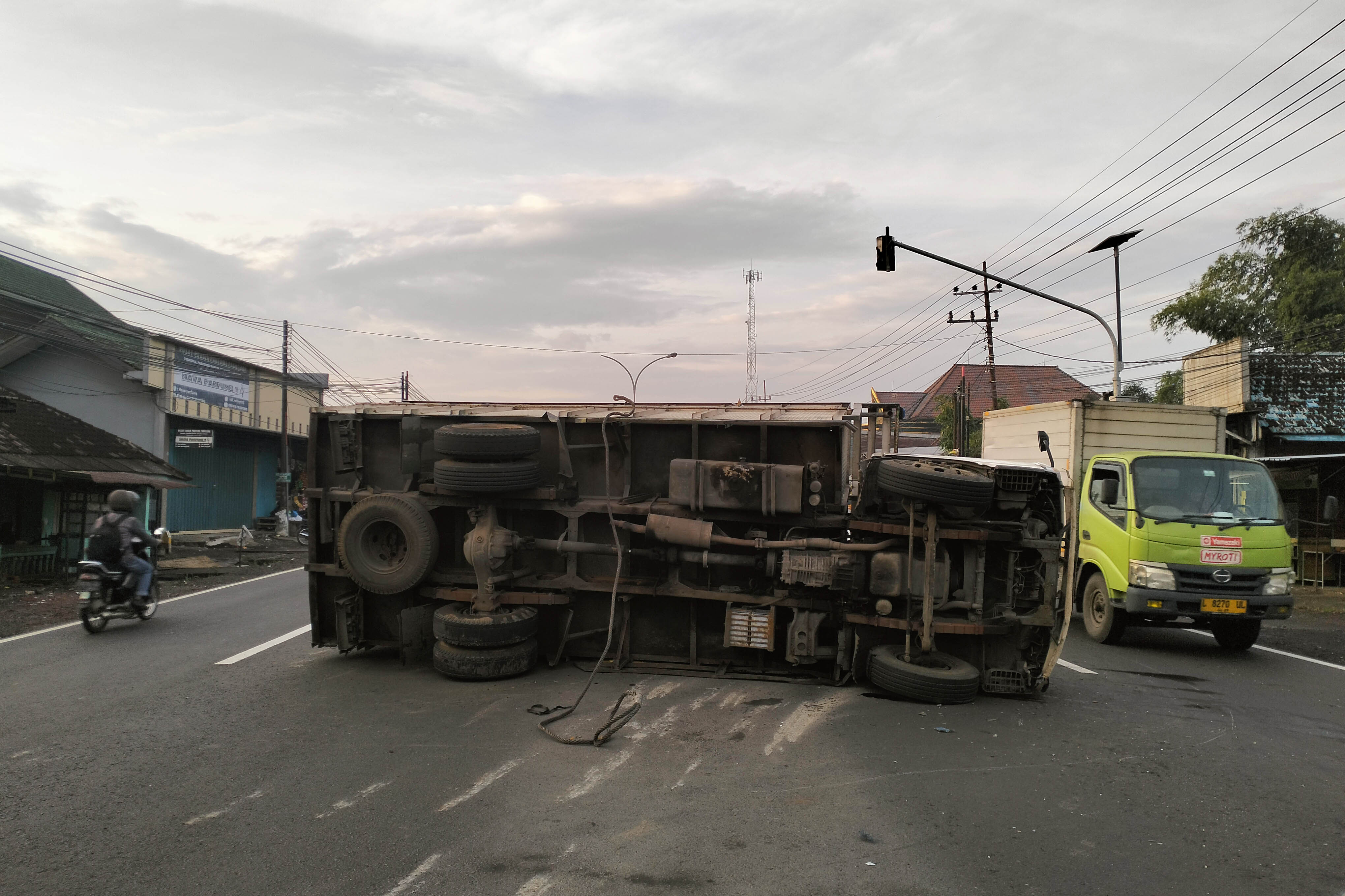 TUTUP JALAN: Truk yang dikemudikan Bayu Krisna Irawan, terguling di Jalan Nasional Surabaya-Malang, Desa Suwayuwo, Kecamatan Sukorejo, Kabupaten Pasuruan,. Minggu (15/2).