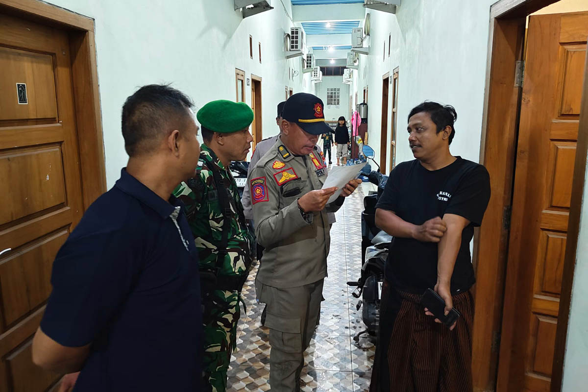 PERIKSA: Petugas Satpol PP Kota Pasuruan saat meminta keterangan terhadap salah satu penghuni kos. Razia itu dilakukan, untuk meminimalisir penyalahgunaan kos-kosan.