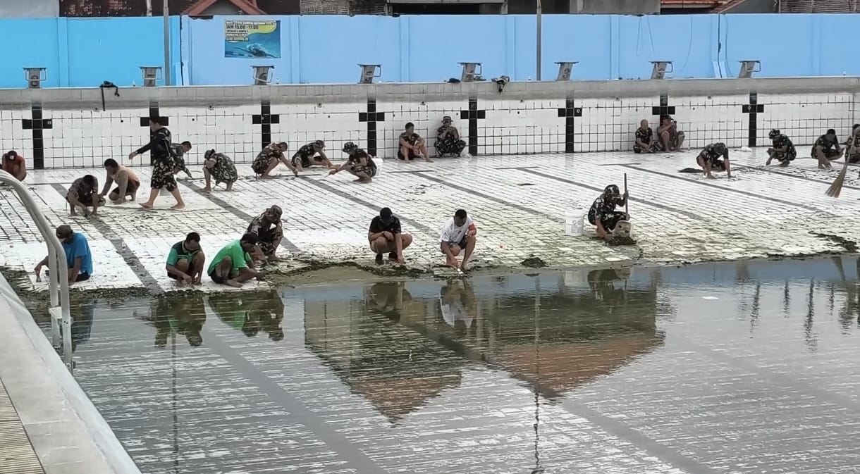 KERJA BAKTI: Puluhan personel TNI Kodim 0820 Probolinggo dan Koramil Wonoasih membersihkan Kolam Renang Olimpik di GOR Mastrip Kota Probolinggo.