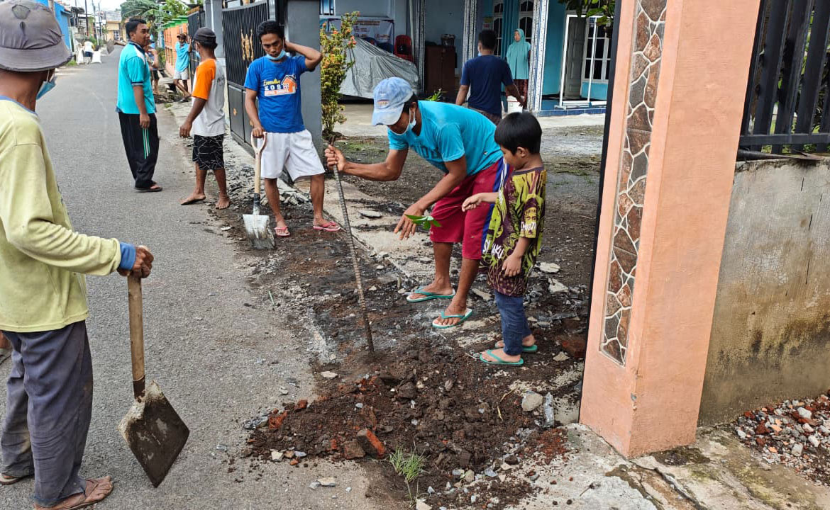 GOTONG ROYONG: Warga mengeruk saluran drainase di Jalan Musi, Jrebeng Kulon.