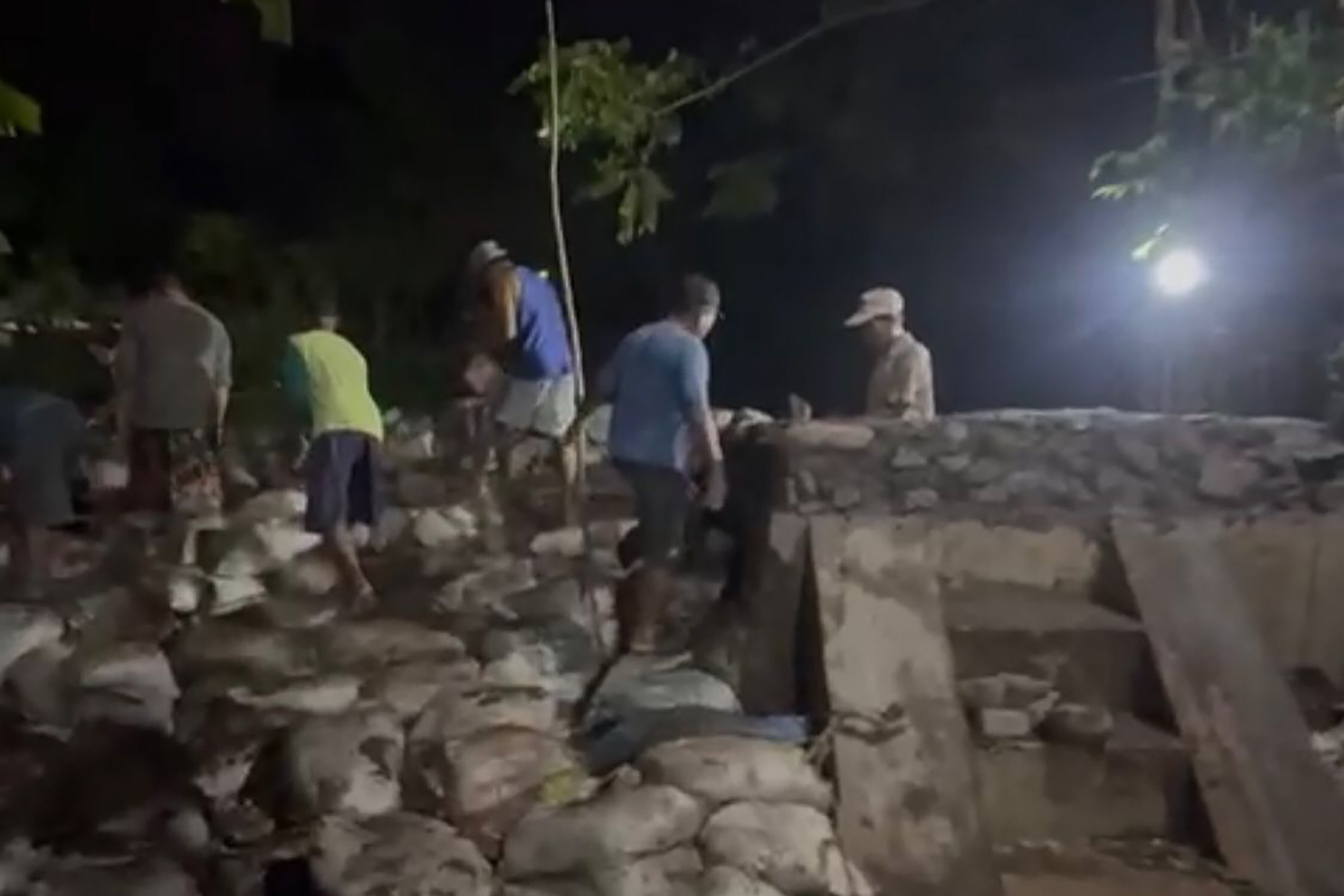 GOTONG ROYONG: Sejumlah warga Desa Tambakrejo, Kecamatan Tongas, memperbaiki parapet di RT 12-13/RW 4 Dusun Prapatan, Jumat (20/2) malam.
