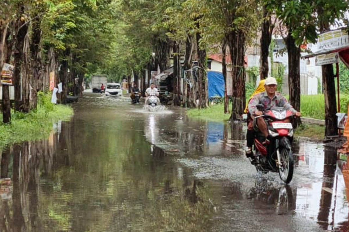 NEKAT: Sejumlah pengendara motor nekat melintasi banjir genangan yang terjadi di Jalan WR Supratman masuk Desa Bulu Kecamatan Kraksaan.
