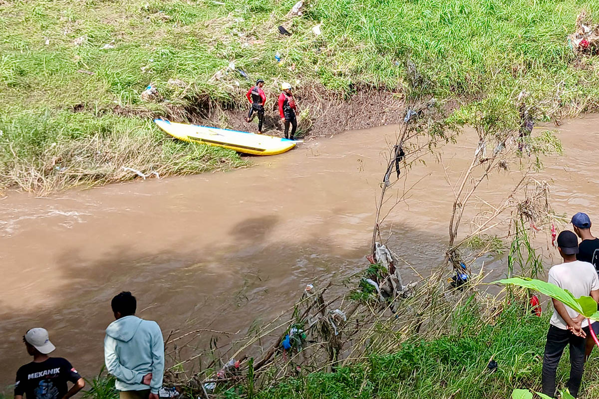 SISIR SUNGAI: Petugas menyisir Sungai Pancarglagas di Paiton untuk mencari Aura Firza Farzana yang tenggelam dan hanyut terbawa arus.  
