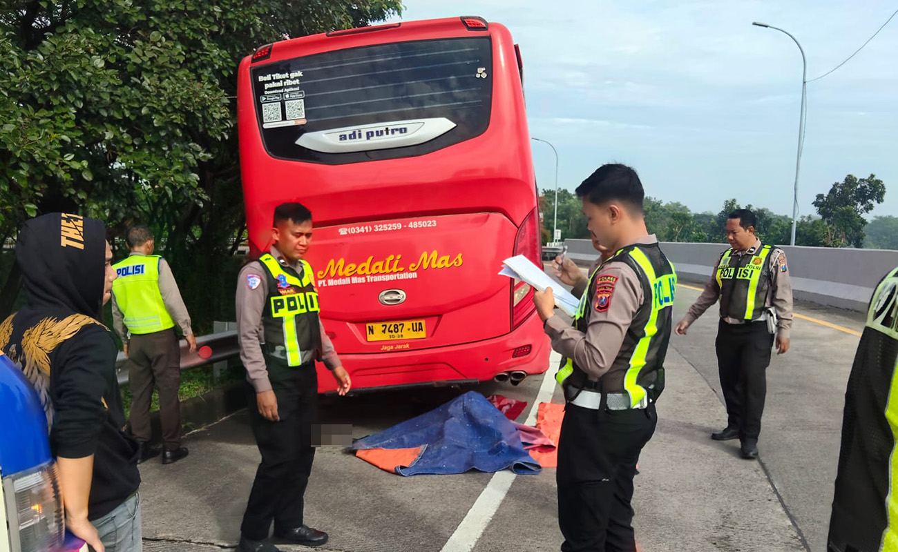 NAHAS: Petugas saat hendak mengevakuasi jenazah sopir bus Medali Mas yang tewas terlindas busnya sendiri. 