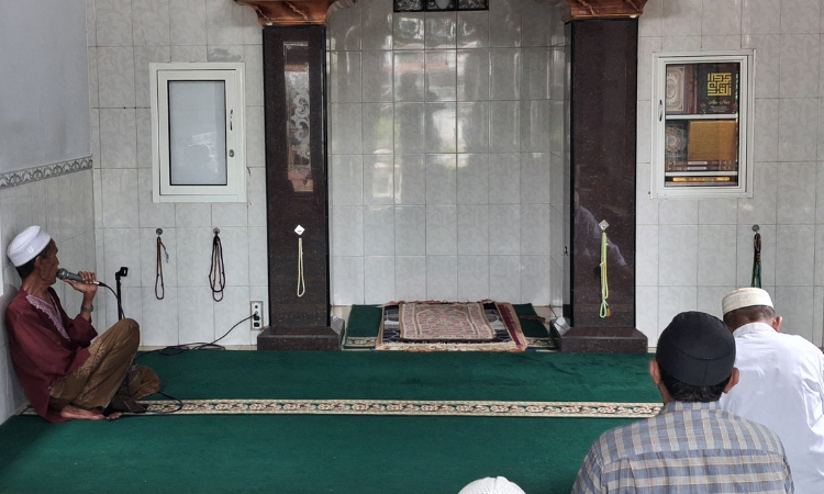 NIAT MENGABDI: Arifin (kiri) menderas zikir usai azan dan sebelum salat jemaah dimulai.