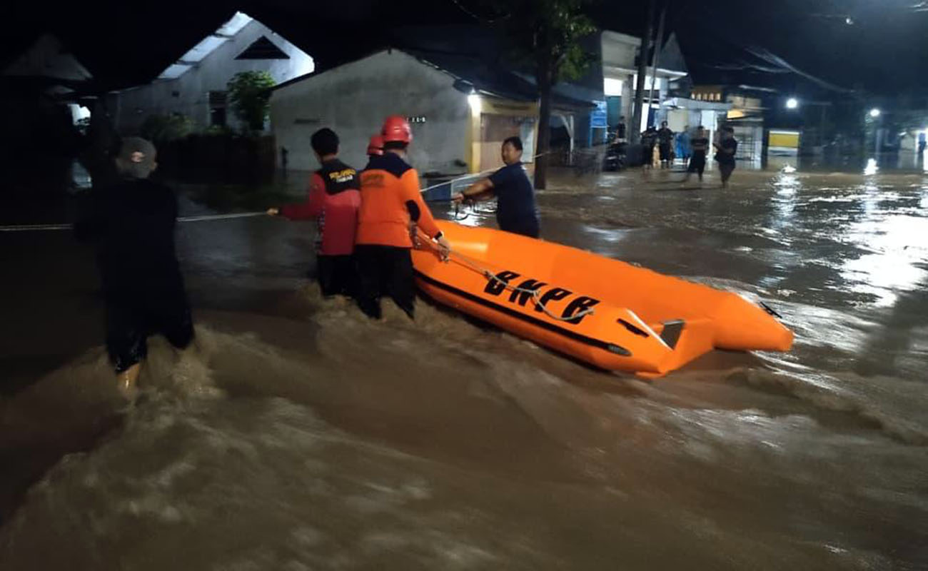 PARAH: Petugas BPBD saat mengevakuasi lansia yang terjebak banjir Kraksaan, akhir pekan lalu. (Dok. Radar Bromo)