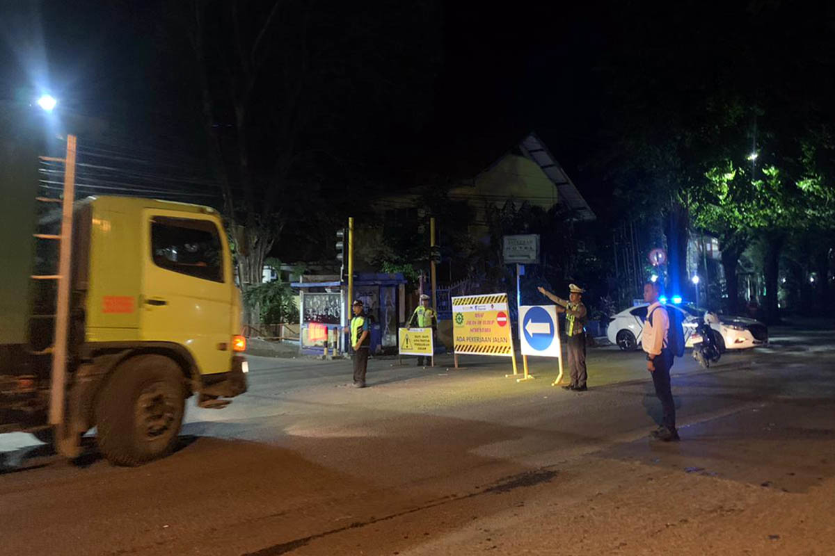 ATUR ARUS: Petugas kepolisian saat melakukan pengaturan arus. Hal ini mendandai persiapan untuk perbaikan jalan.