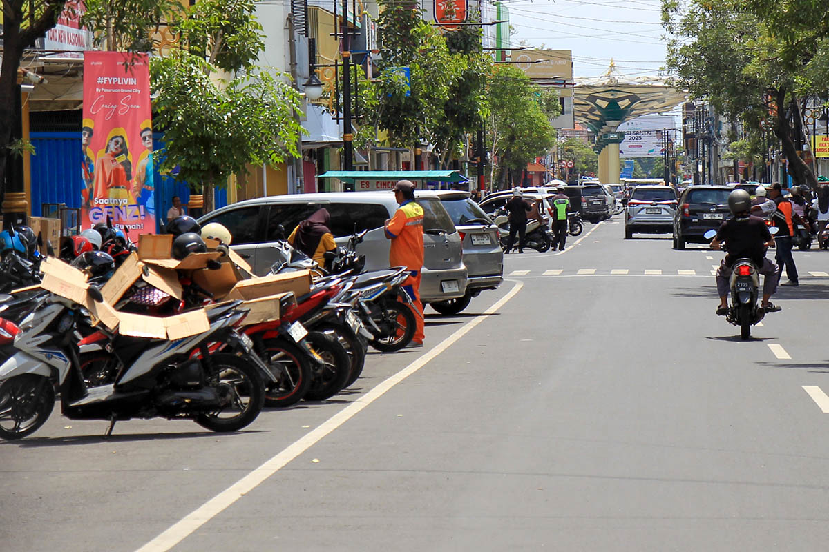 BERDERET: Sejumlah kendaraan yang parkir di seputar alun-alun kota. Tampak jukir yang tengah bertugas.