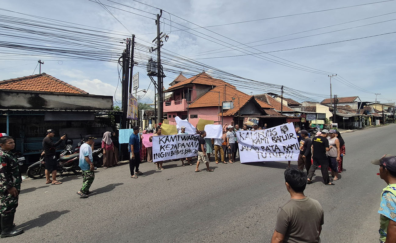 PROTES: Sejumlah warga Dusun Melian, Desa Kejapanan, Kecamatan Gempol saat menggelar aksi di tepi jalan raya Pasuruan-Mojokerto, Minggu (1/3). Mereka protes lantaran rumahnya kerap terendam banjir.