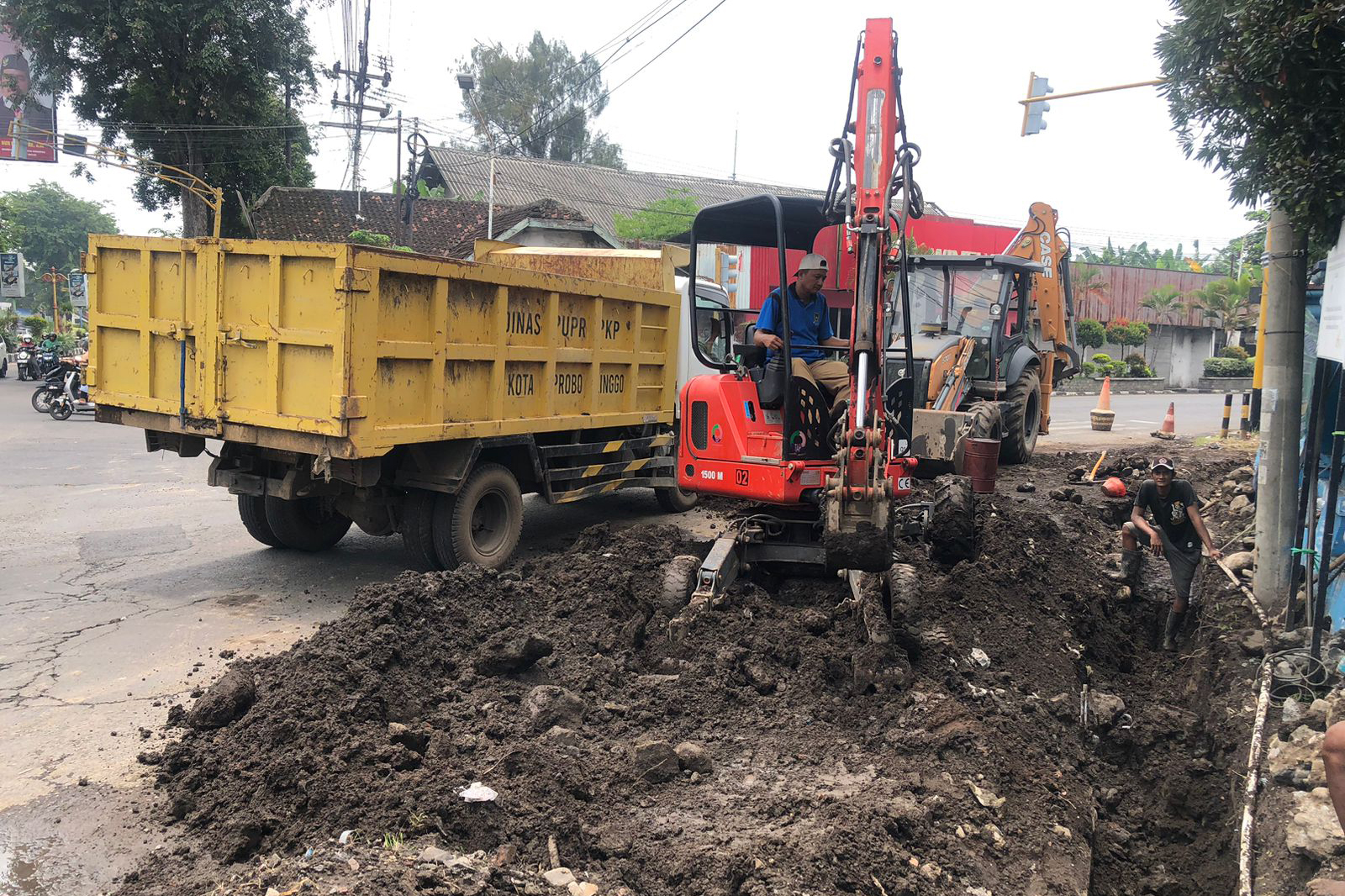 KERUK: Pekerja dari Dinas PUPR PKP Kota Probolinggo saat melakukan normalisasi saluran drainase di simpang empat Randur Pangger, Kota Probolinggo, Senin (2/3) siang.