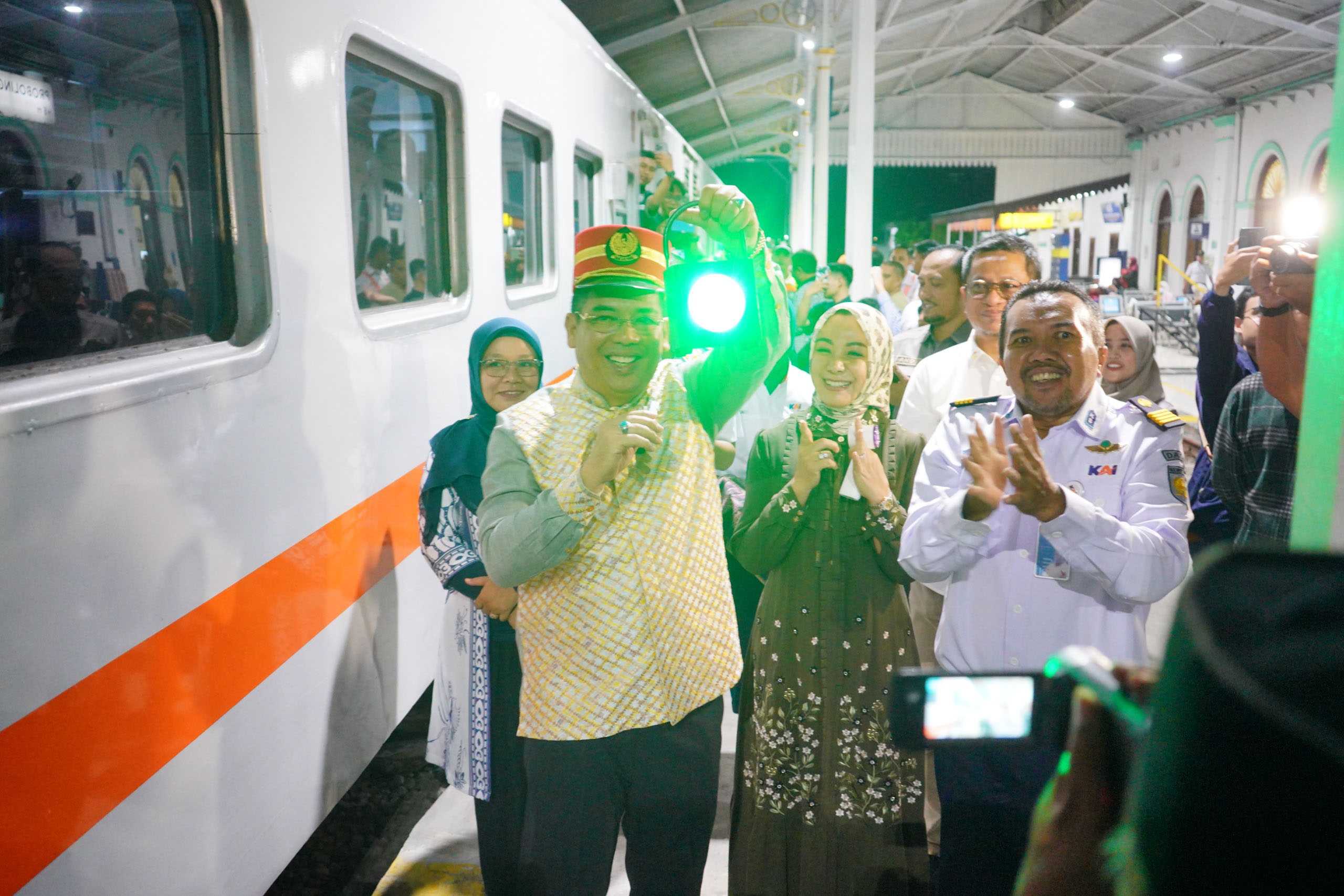 BERANGKAT: Wali Kota Probolinggo, dr. H. Aminuddin, membunyikan peluit tanda resmi diberangkatkannya KA Commuter Line Supas Probolinggo dari Stasiun Probolinggo, Minggu malam (1/3).